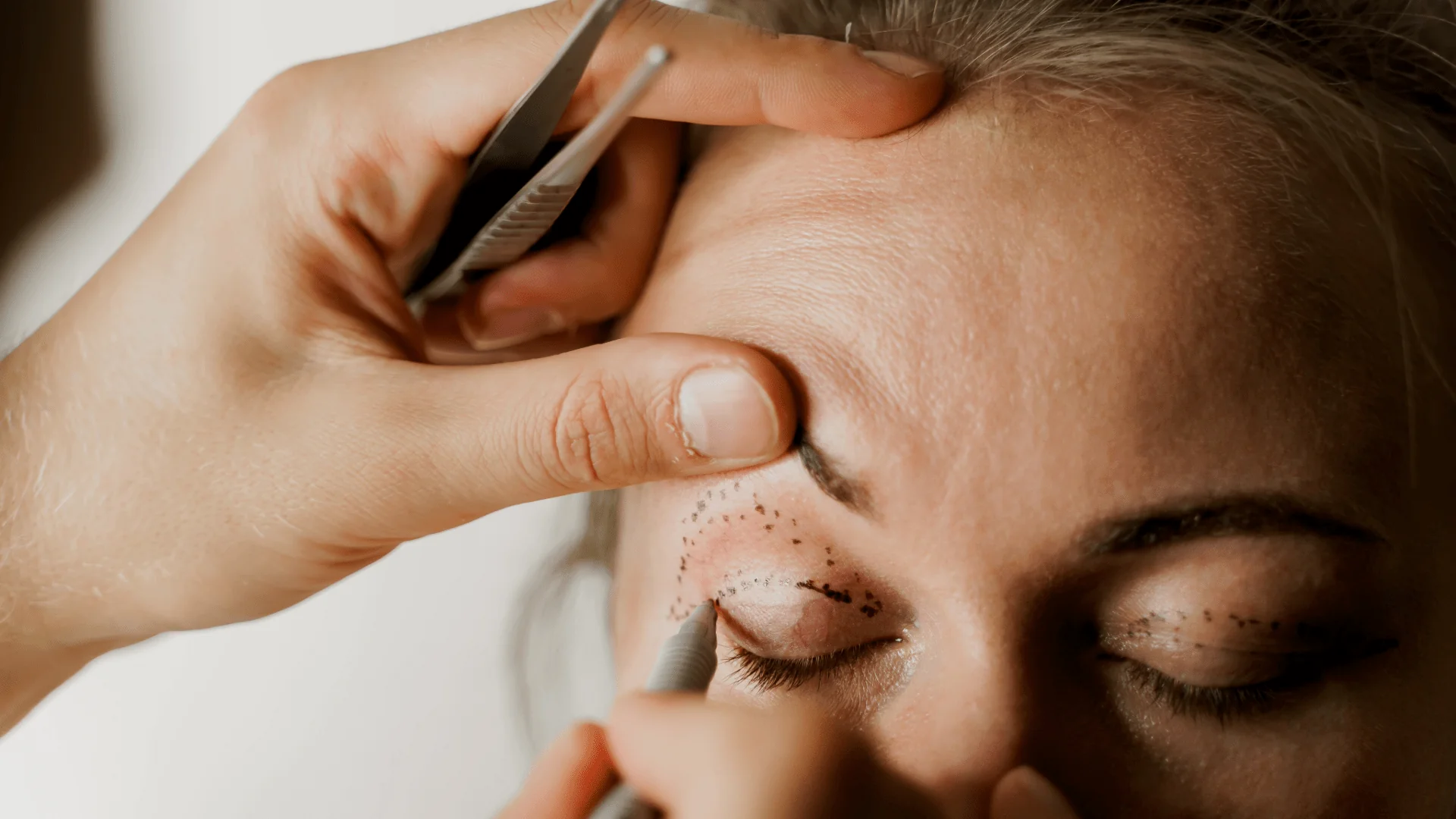 Unbenannt-42 - Dr. Pumberger Close-up of a cosmetic procedure: a technician uses a tool near a client's eye with dotted markings around the eye for semi-permanent makeup, awaiting eyeliner.