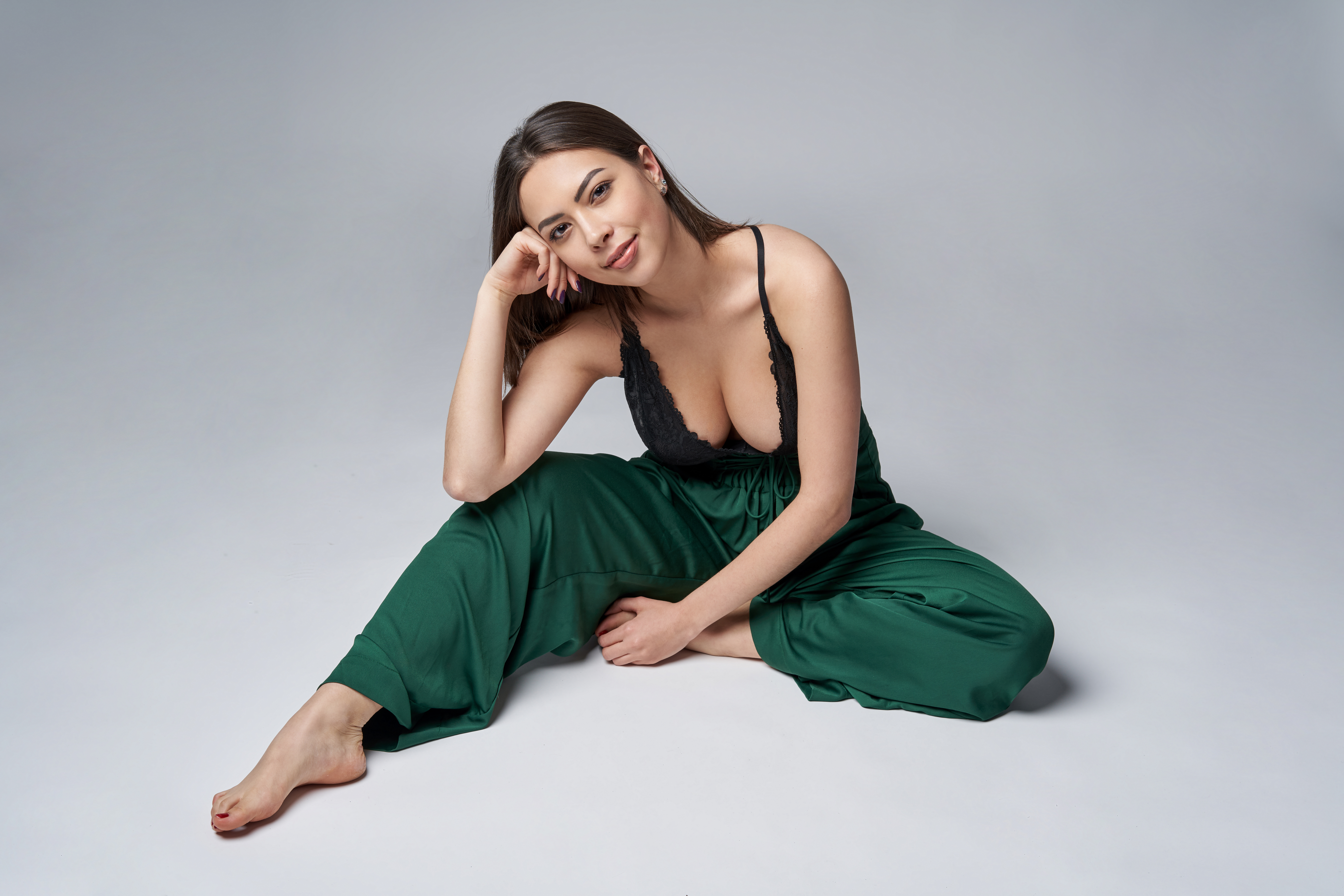 Sensual brunette female in green trousers and top with deep cleavage - Dr. Pumberger